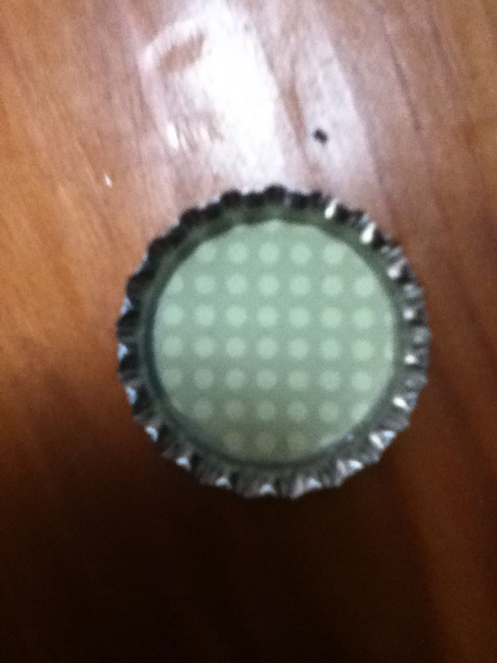 Put your paper circle on the bottle cap, and press down to spread out the lacquer. It is ok if some leaks up from under your paper. Let dry for 5-10 minutes.