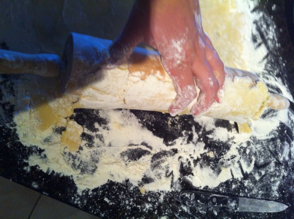 Put your rolling pin on top of the crust at one edge and gently lift your crust with a knife making sure it's not sticking to the surface and roll back the pin continuing to lift the crust around pin.