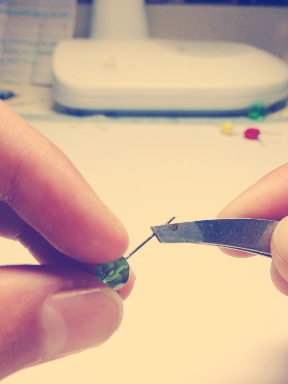 Put your tweezers/pliers about here on the metal, making sure you have a firm grip. Should be a little over halfway above the bead.