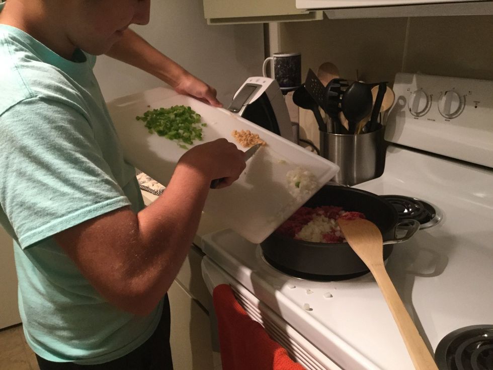 Putting my chopped up veggies and garlic in with the ground beef.