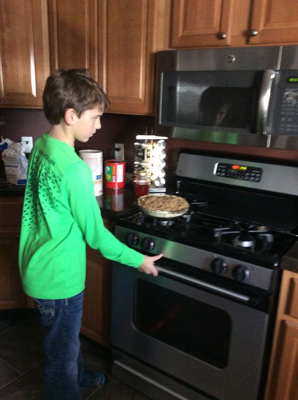 Putting the pie in the oven to cook.