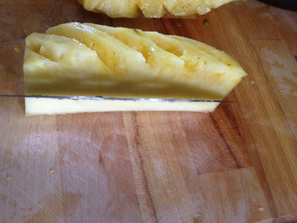 Quarter the pineapple through the center core. Place the quarter on its side (as pictured) and cut the core out at a 45\u2022 angle.