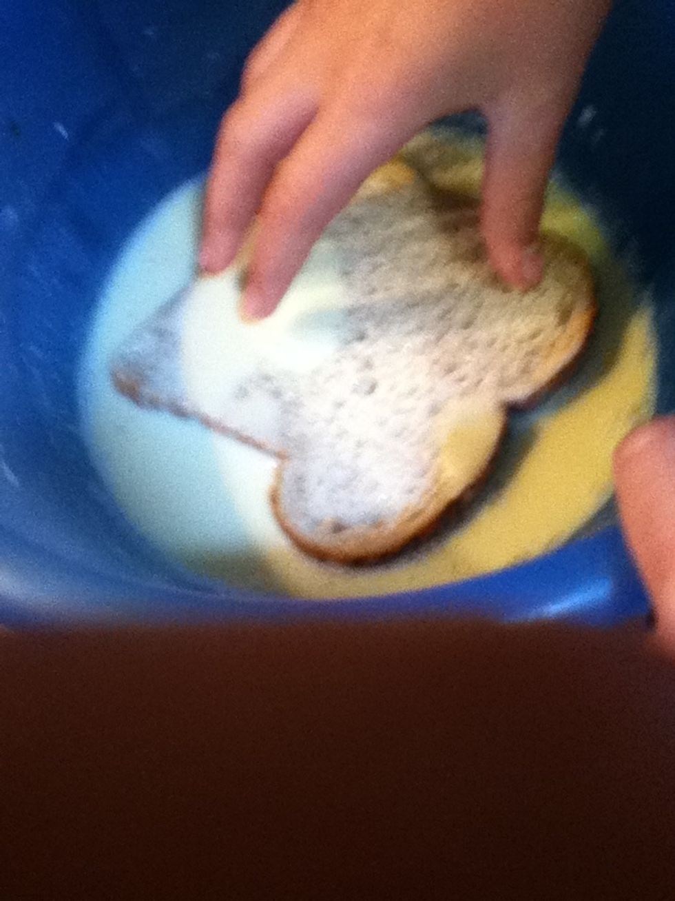 Quickly dunk a piece of bread in the mixture, making sure both sides are coated