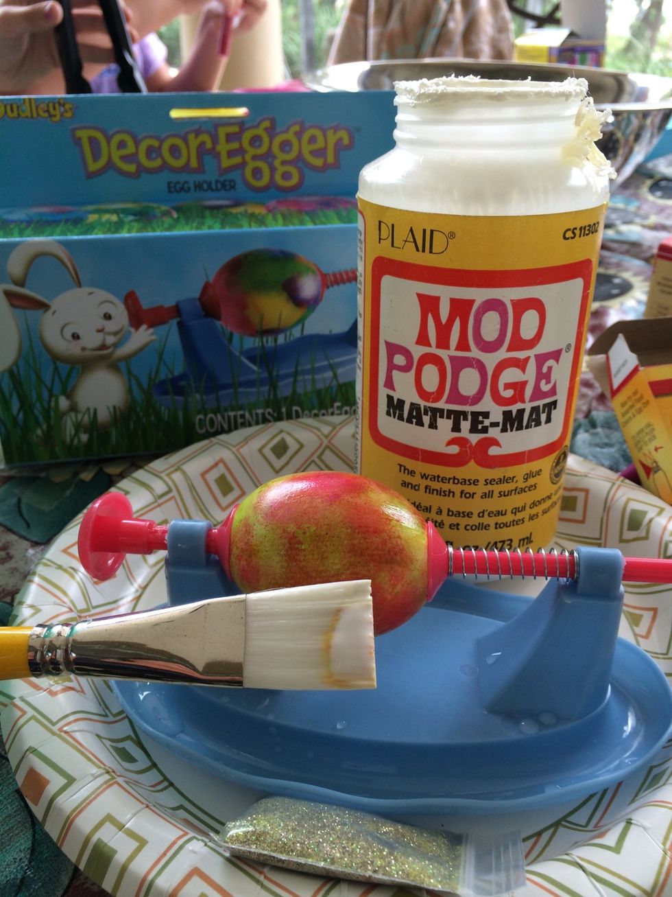 Quickly place it in this cool egg hold. I purchased this at Walmart. And sprinkle glitter on the egg.