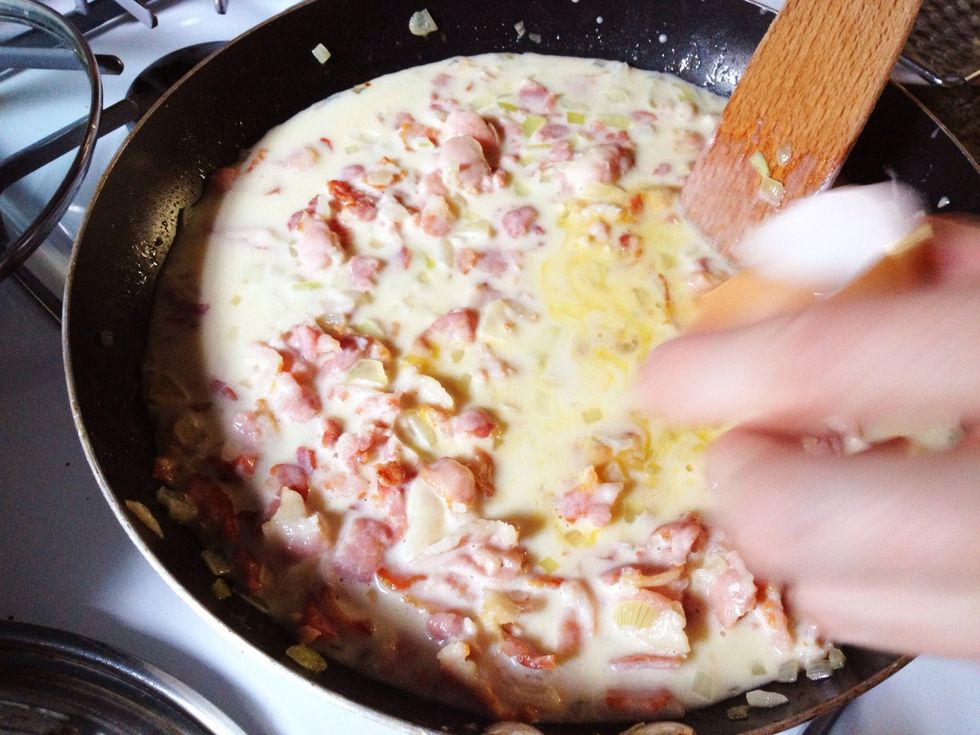 Quickly stir in the egg yolk, and grind in some fresh black pepper.