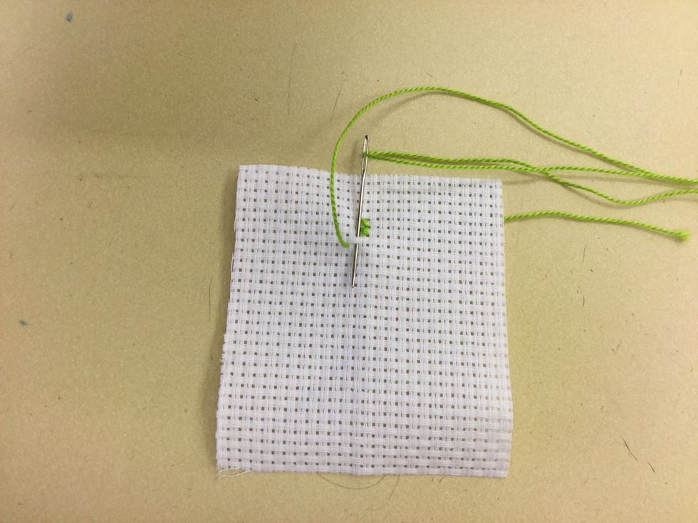 R\u00e4kna ut var du ska b\u00f6rja med ditt broderi. B\u00f6rja att sy korsstygn. B\u00f6rja med att sticka upp n\u00e5len i rutans nedre v\u00e4nstra h\u00f6rn och g\u00e5 snett \u00f6ver rutan och stick ner n\u00e5len.