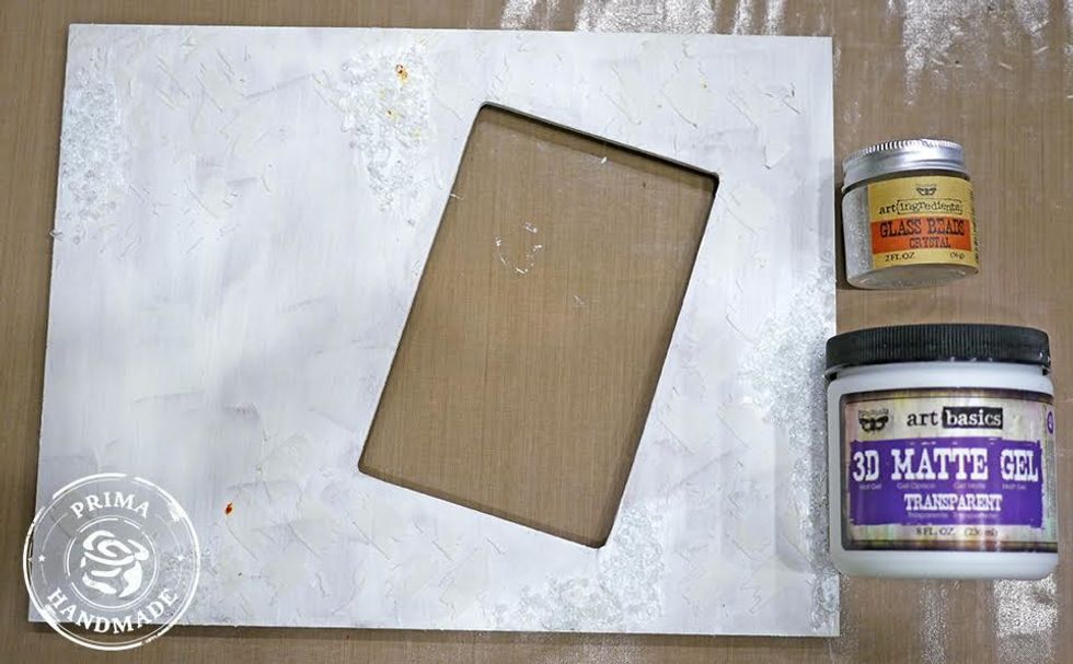 Randomly adhere glass beads to photo frame using gel paste.