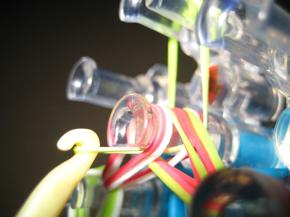 Reach hook under all bands and bring to the top peg.