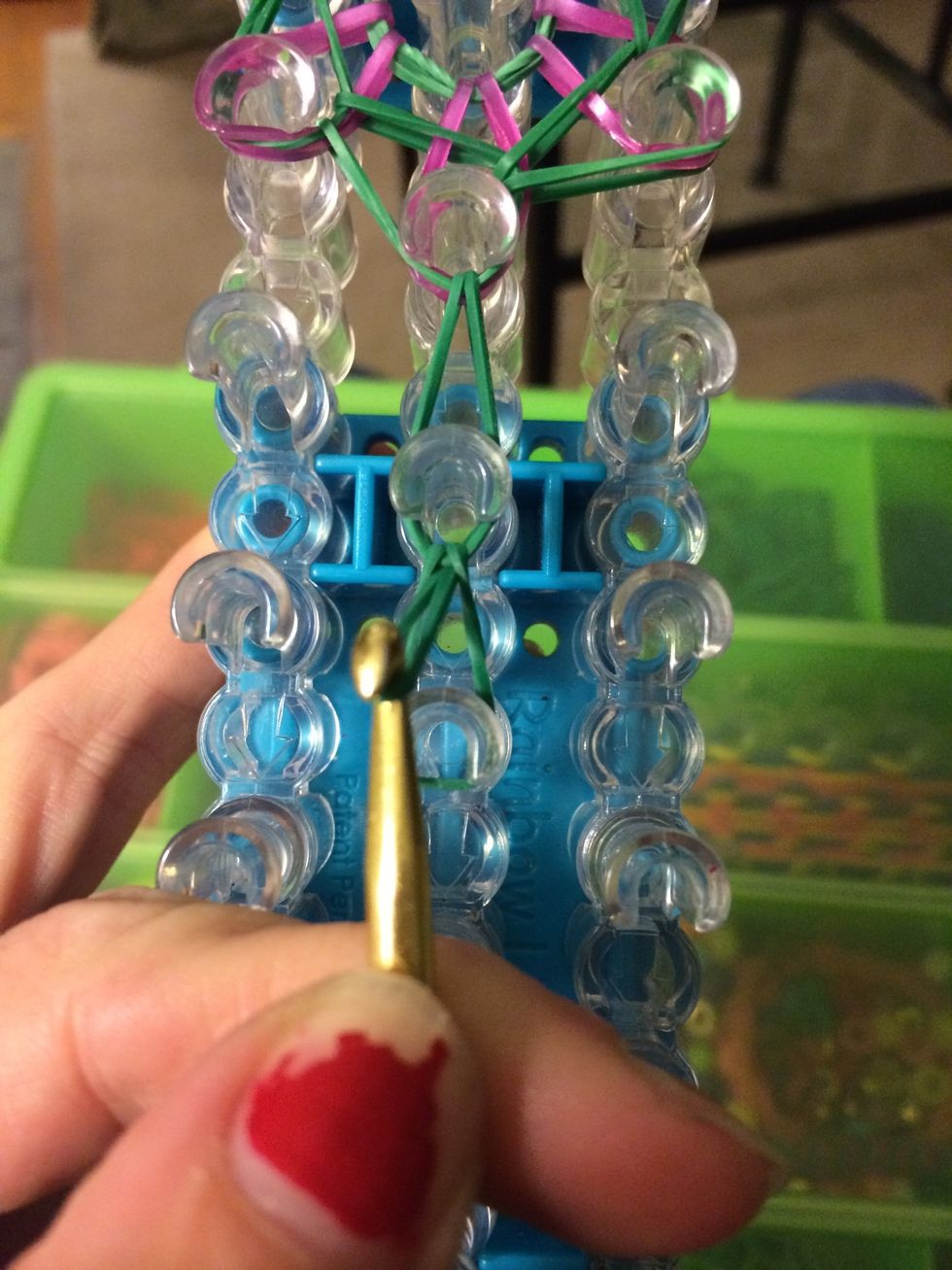 Reach in the last peg and create a slip knot. Grab the band that's on the bottom and pull it through the band on top. Take the band that is left in the peg and let it go. Pull the other band tighter.