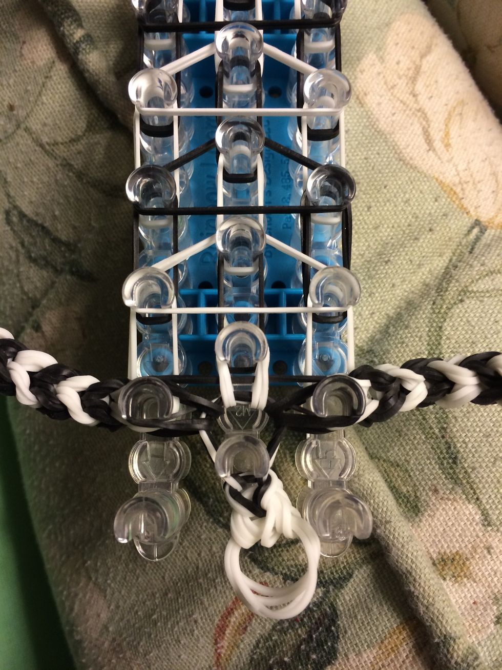 Reach into the peg of the tail and grab the black bands and white bands. Loop them forward.