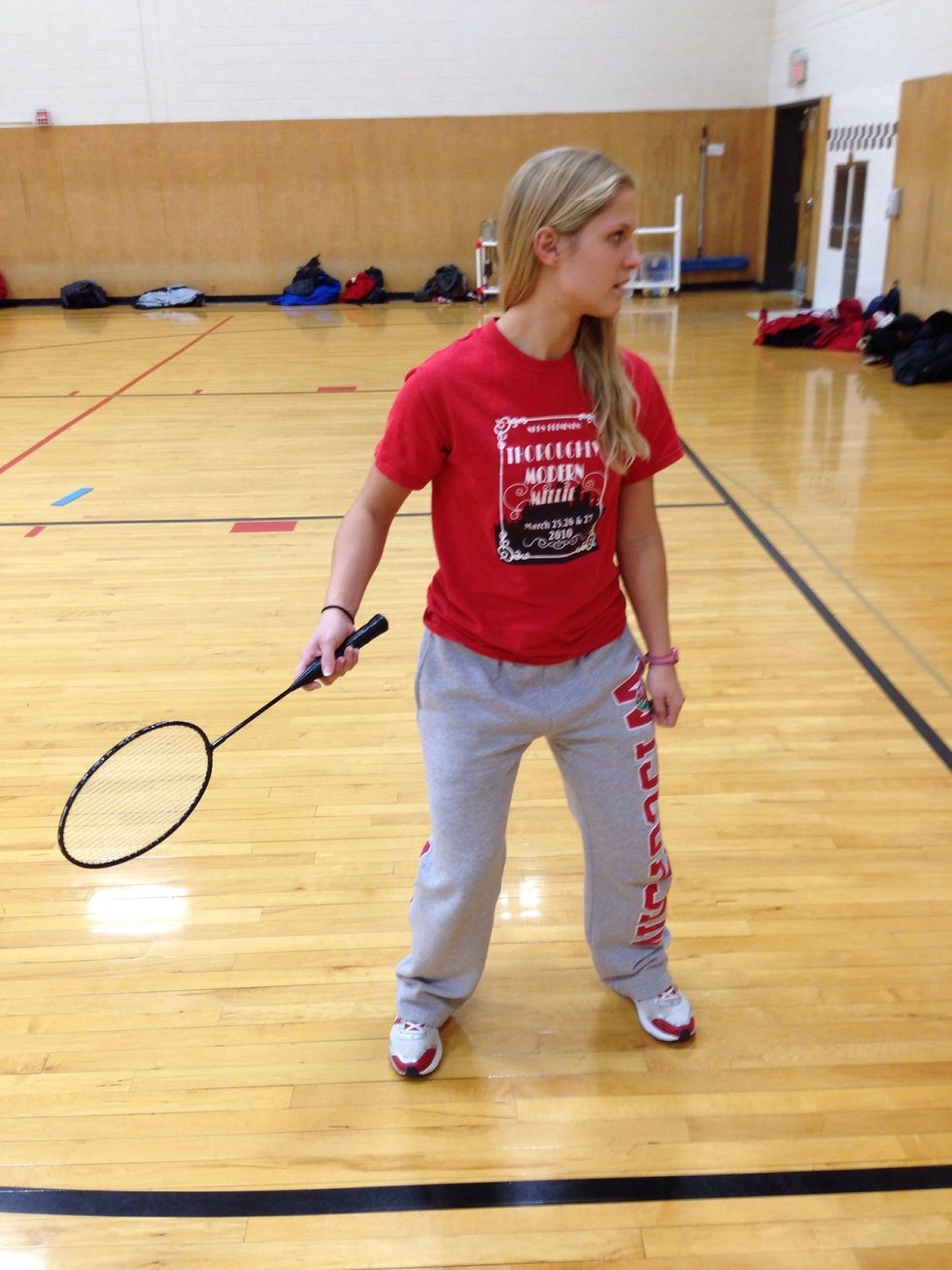 Ready position. Feet about shoulder width apart, racquet in dominant hand using the forehand shake grip, knees slightly bent, ready to move towards the shuttle.