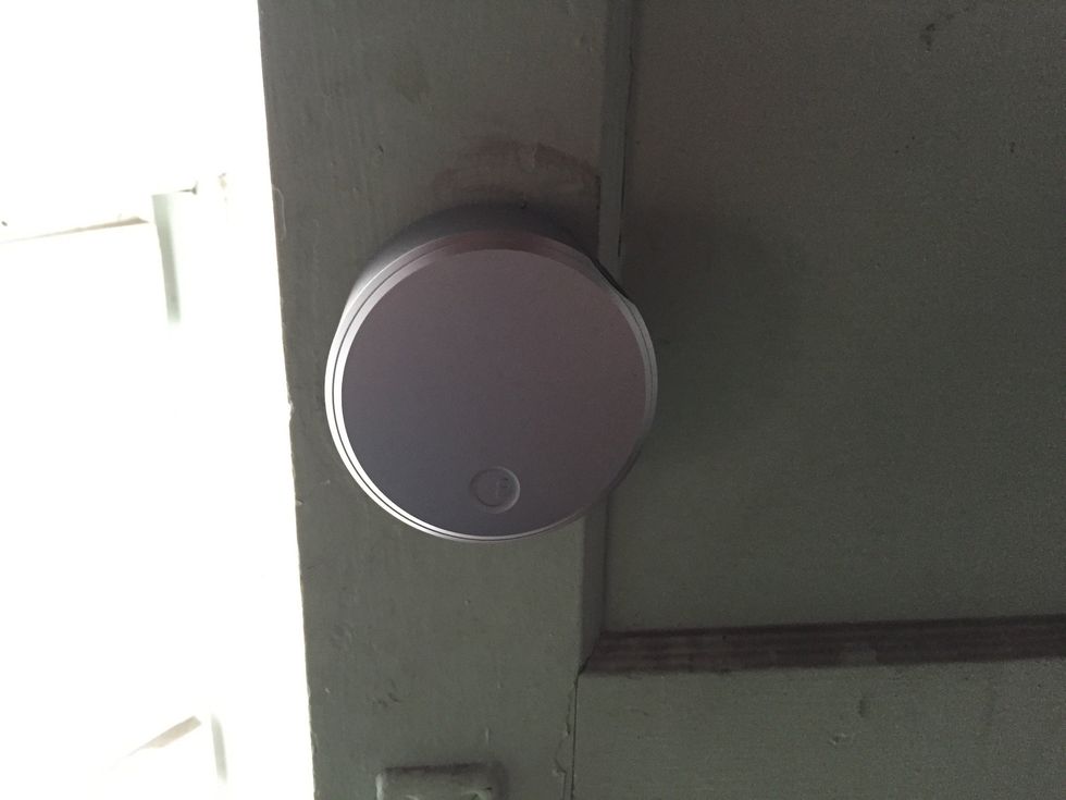 Reattach the faceplate to the lock. Align the hooks with the August Smart Lock. The faceplate will lock into place with the logo at the bottom.