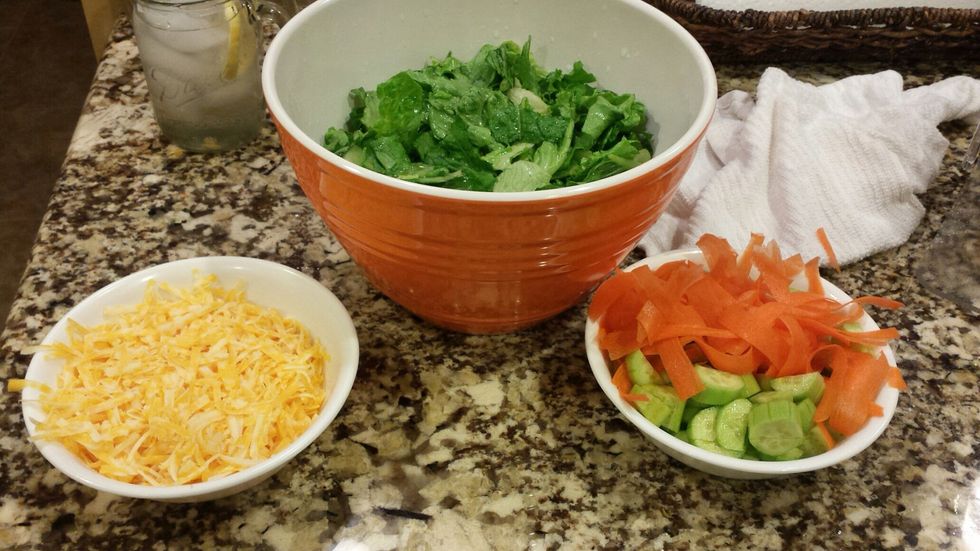 Recipe: Open the bag of lettuce and wash the lettuce. Cut one to two cucumbers into small pieces. Shred one to two carrots and a quarter of a block of cheese.