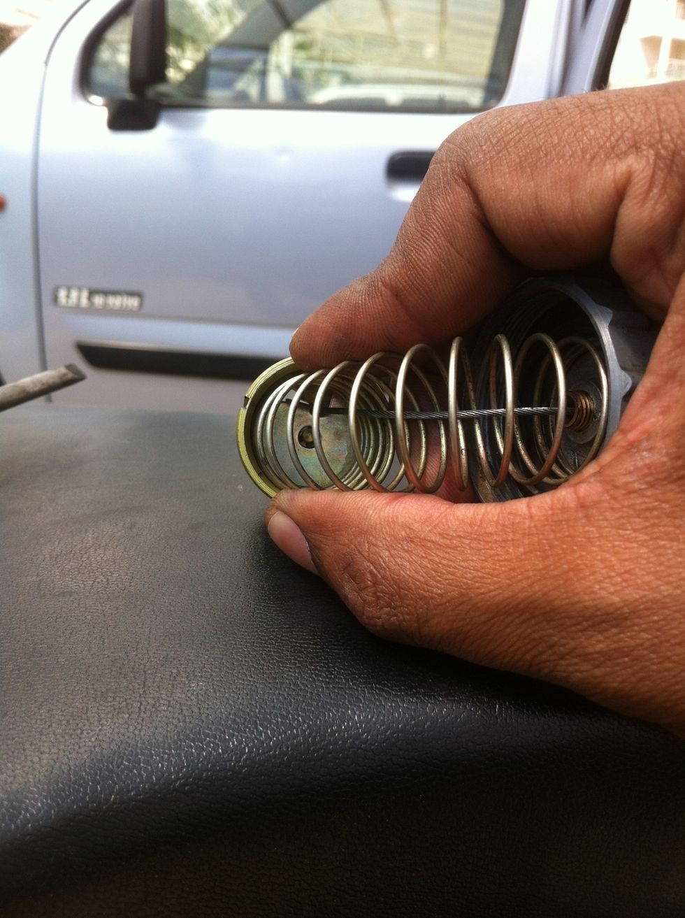 Release the spring to complete the carburetor head assembly.