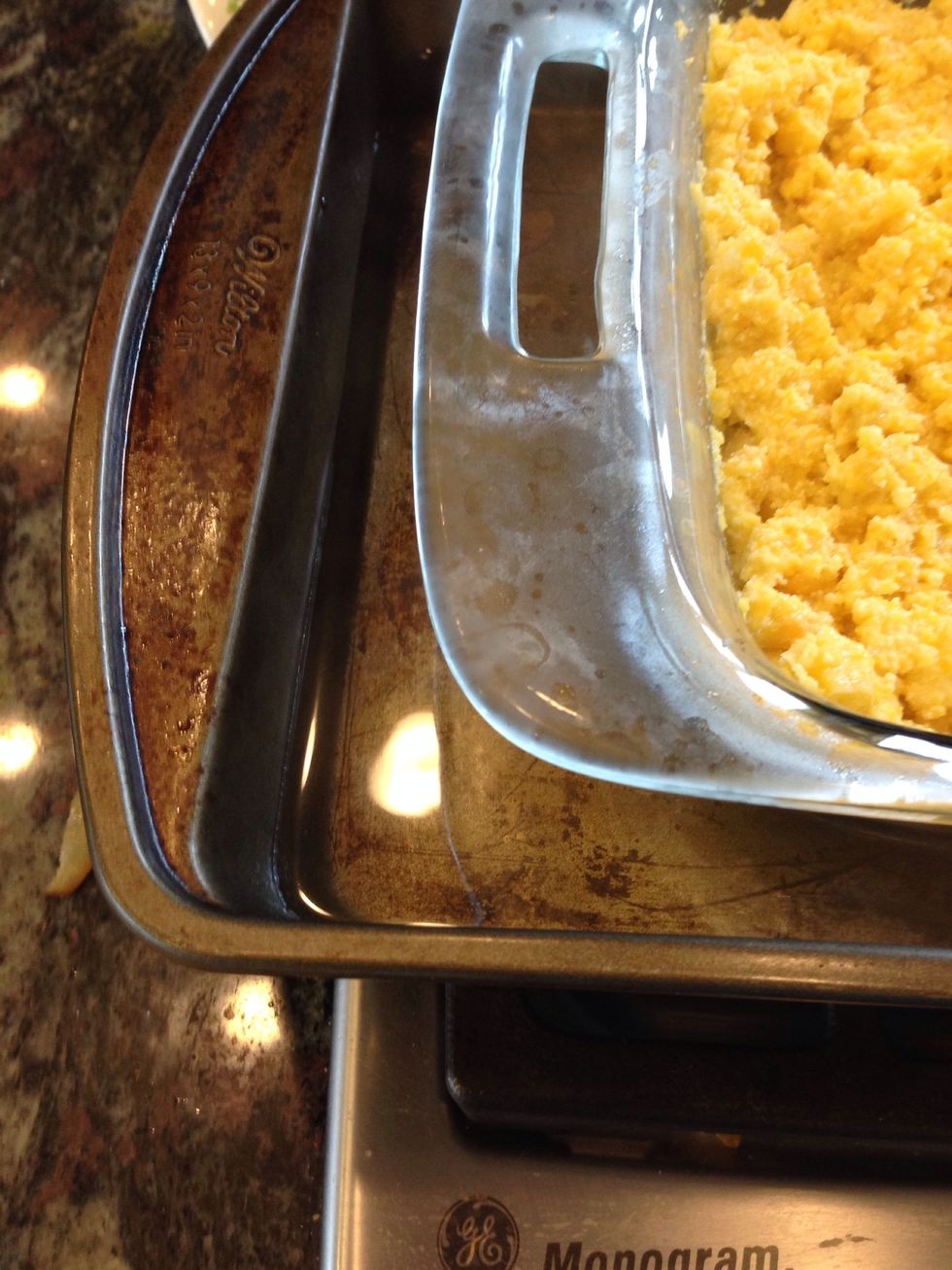 Remember that boiling water? Pour the hot water into a deep baking pan and put the 8x8 pan into it.
