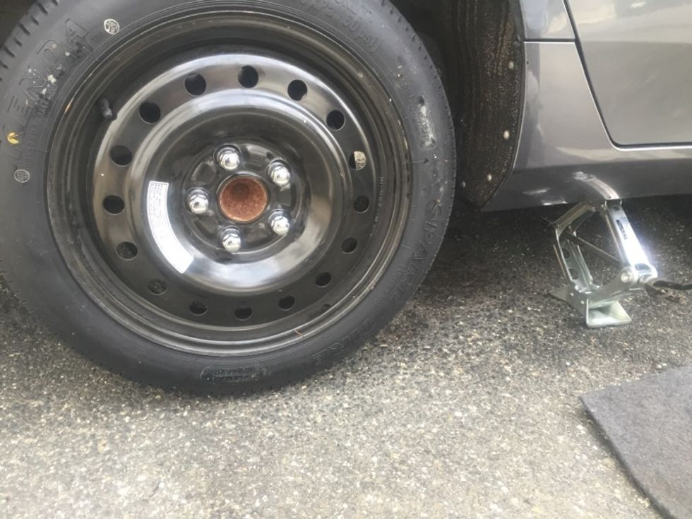 Remember to attach the jack arm assembly to the jack and the lug nut wrench to the arm.