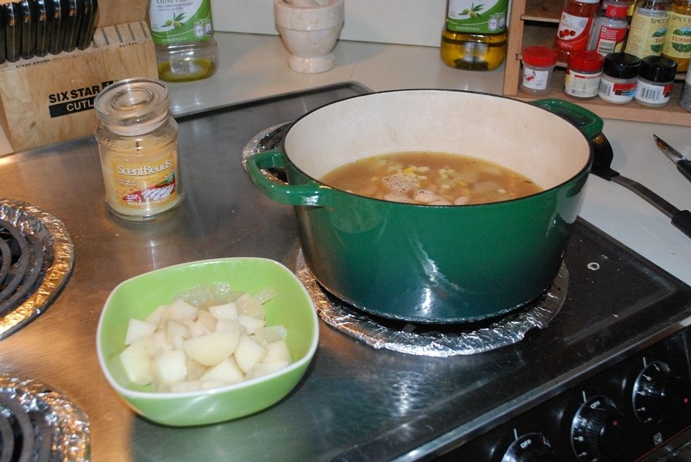 Remove about half of the potatoes & onions into a separate dish then add the beans and one can of corn into the pot