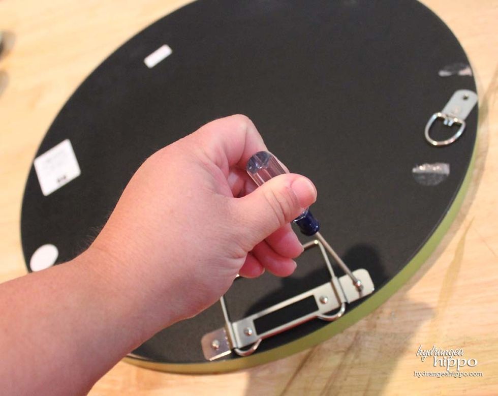 Remove all the hardware from the back of the mirror to create a flat surface for the knives to adhere to.