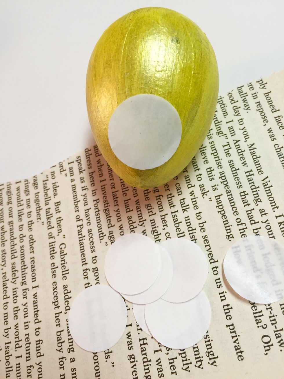 remove backing from circles and place sticky side down on egg. rub with your finger to transfer adhesive. you'll want to work one dot at a time as adhesive is clear and hard to see once applied.