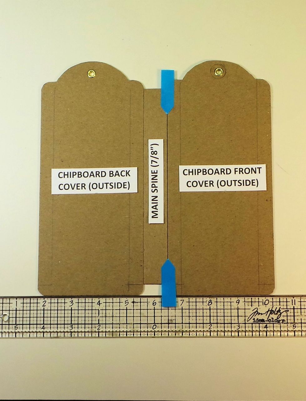 Remove backing from remaining Scor-tape and butt the other chipboard tag against the spine (blue arrows). The outside of tag should be facing up. Use a straight edge to keep everything in alignment.