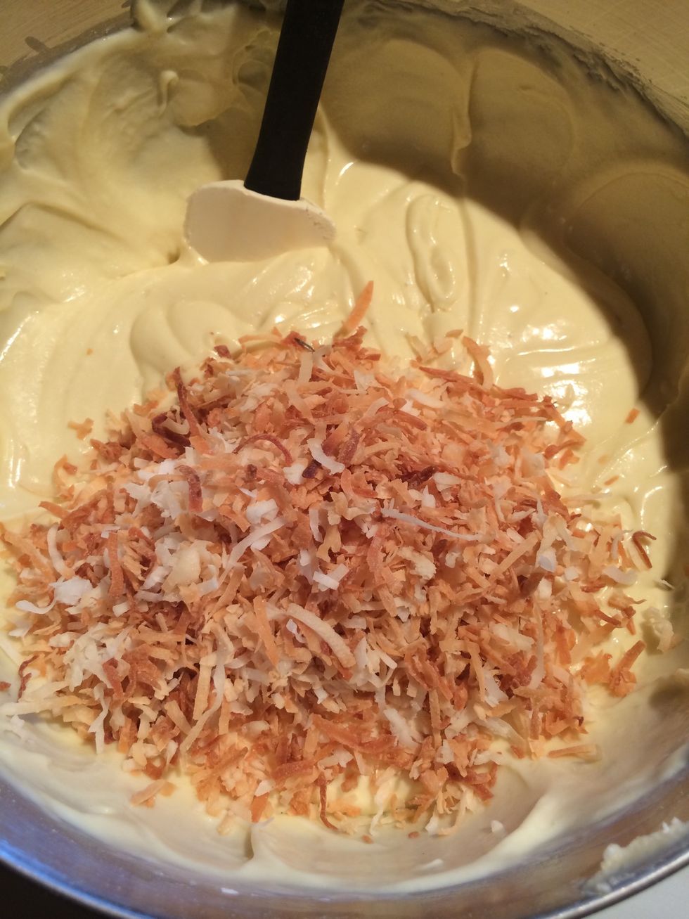 Remove bowl from mixer and add the cooled toasted coconut. Stir in by hand using the rubber spatula. Reserve a handful of toasted coconut to garnish the top of the cake during plate up.