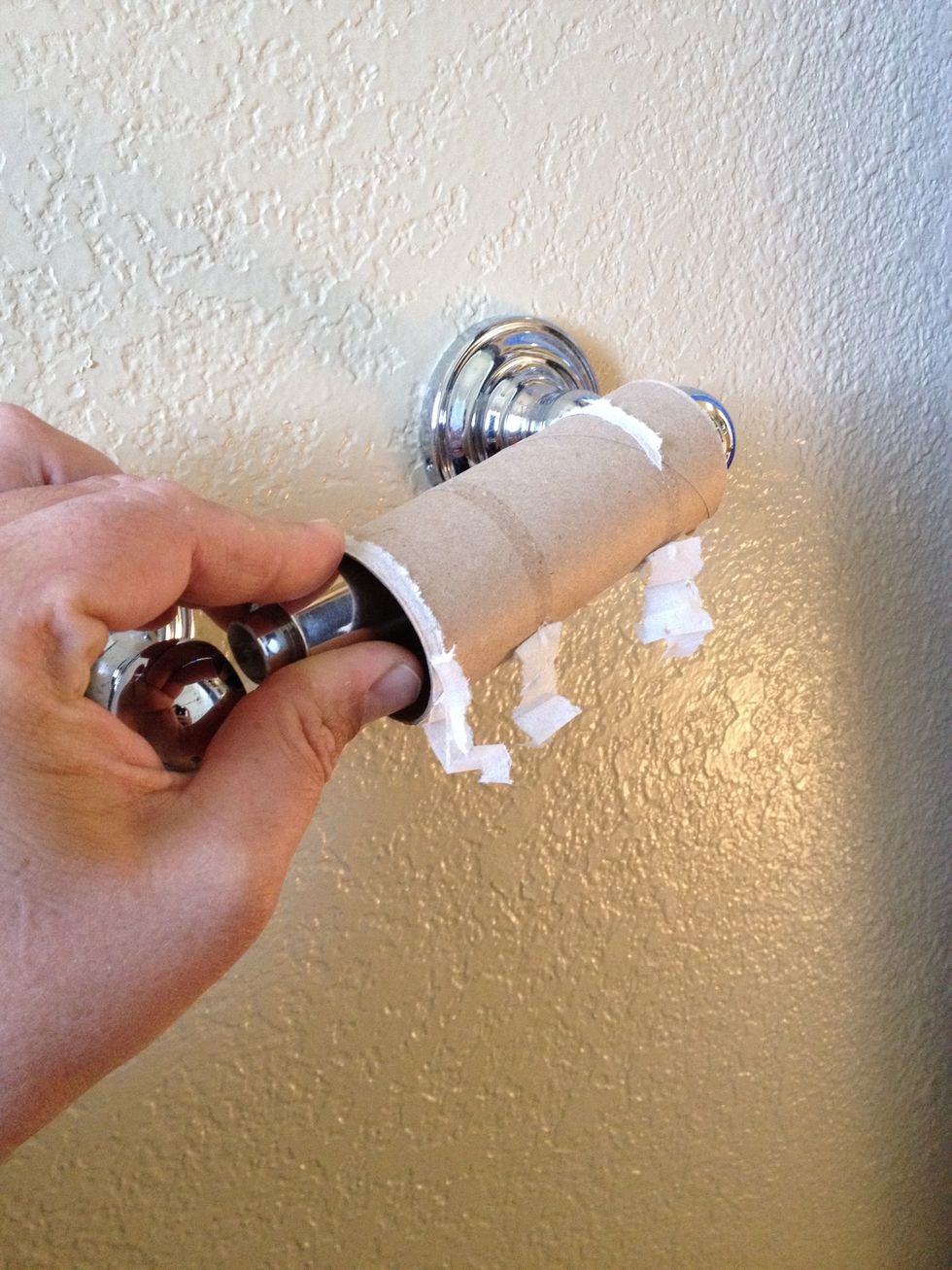 Remove empty roll of TP by depressing spring loaded spindle