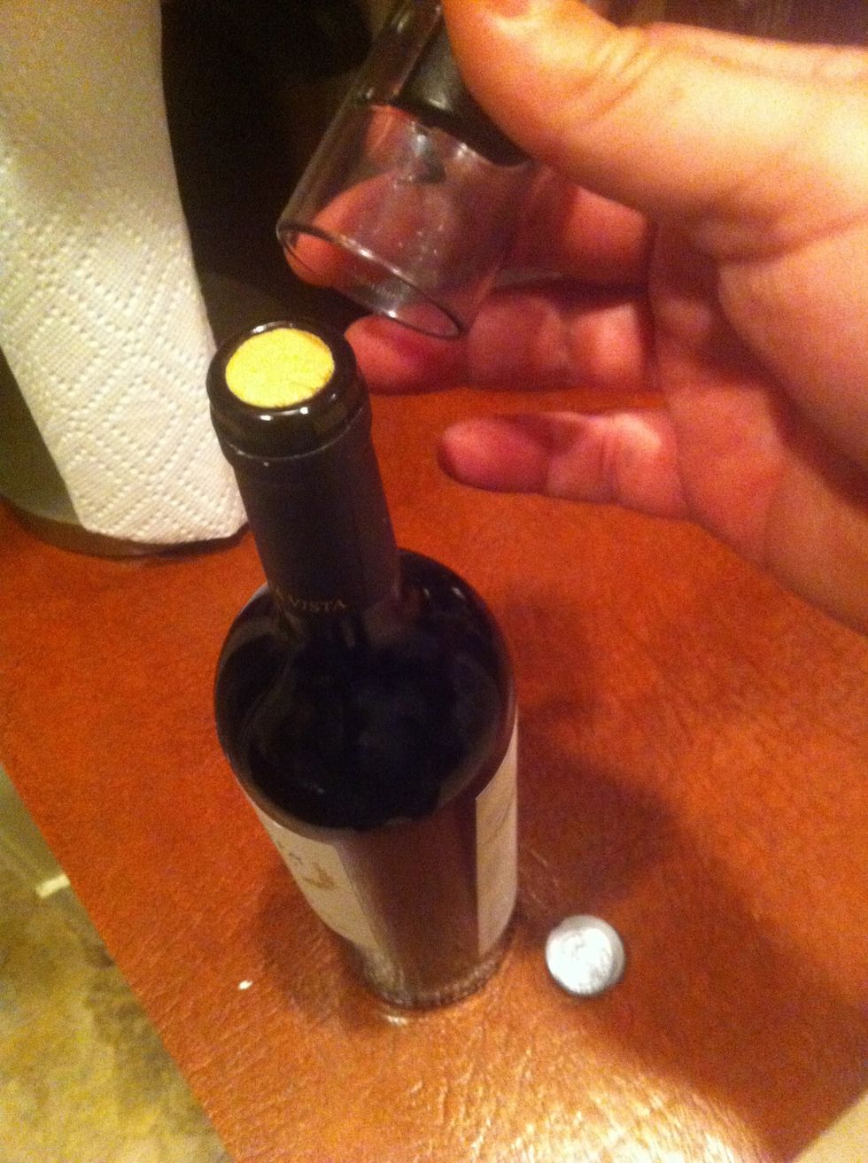 Remove foil hat from bottle, saying "see I told you so silly" in a condescending yet obviously joking manner.