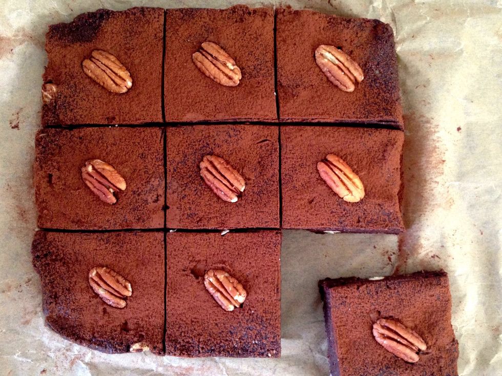Remove from fridge and pull out the baking paper to release the brownies. Dust with cocoa / cacao and if you wish to be super swish, decorate it with pecans or walnuts.