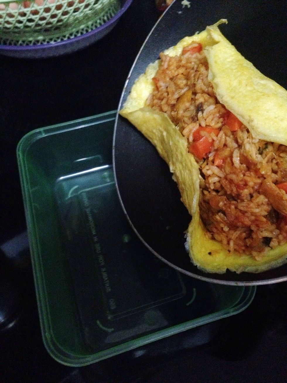 Remove from heat. Tilt the pan and let the stuffed omelete slide to the side of the pan. Hold your lunch box/plate next to the side of pan. Quickly turn/flip the omelette over to the lunch box
