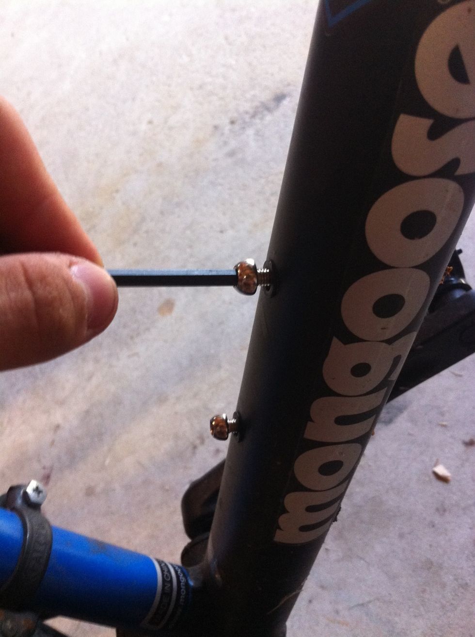 Remove hex screws from bike frame with hex key.