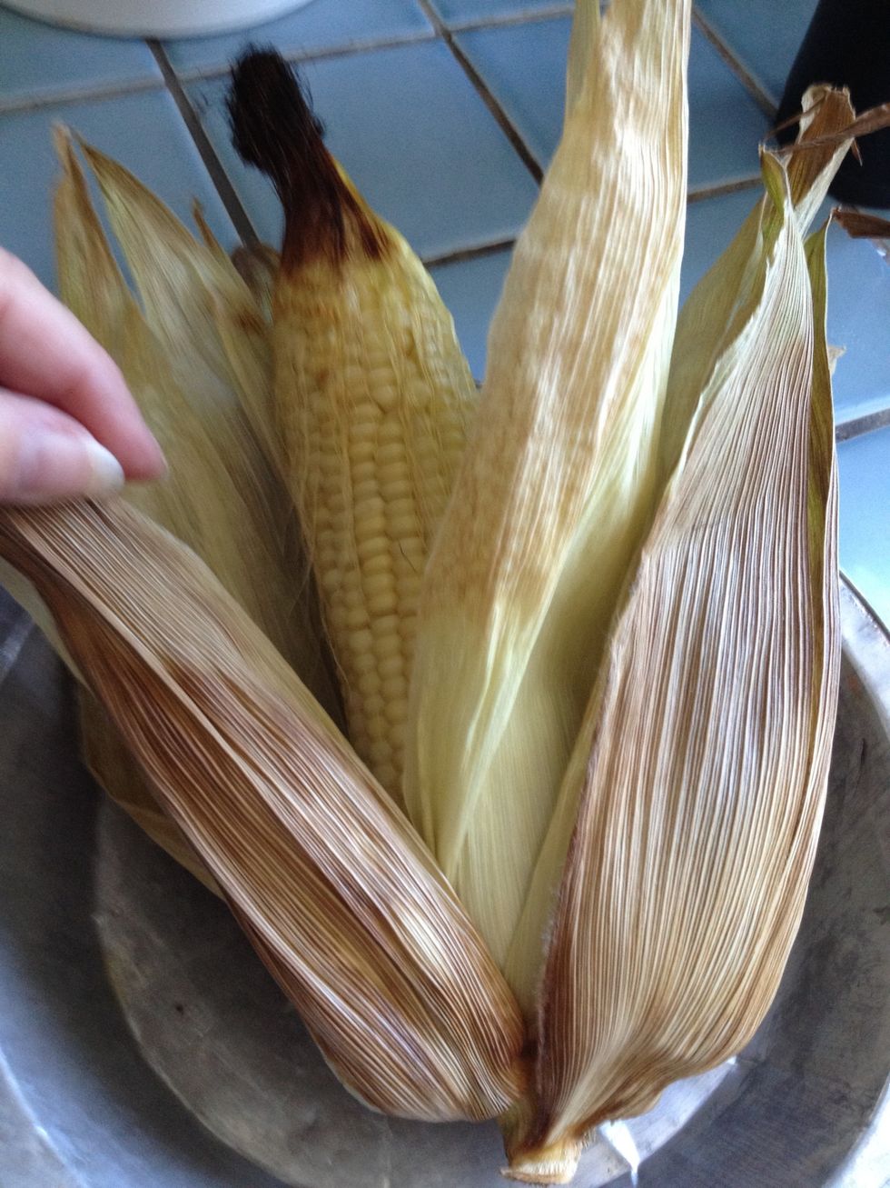 Remove husks from the corn.