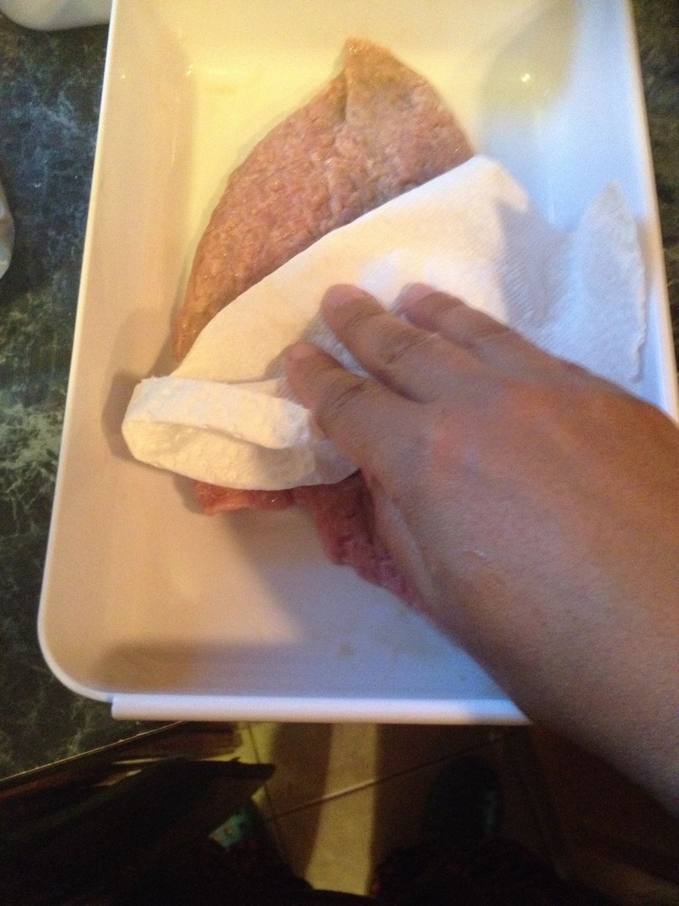 Remove it from the bag. We want to dry it a little bit from the excess buttermilk. We will do this to each steak