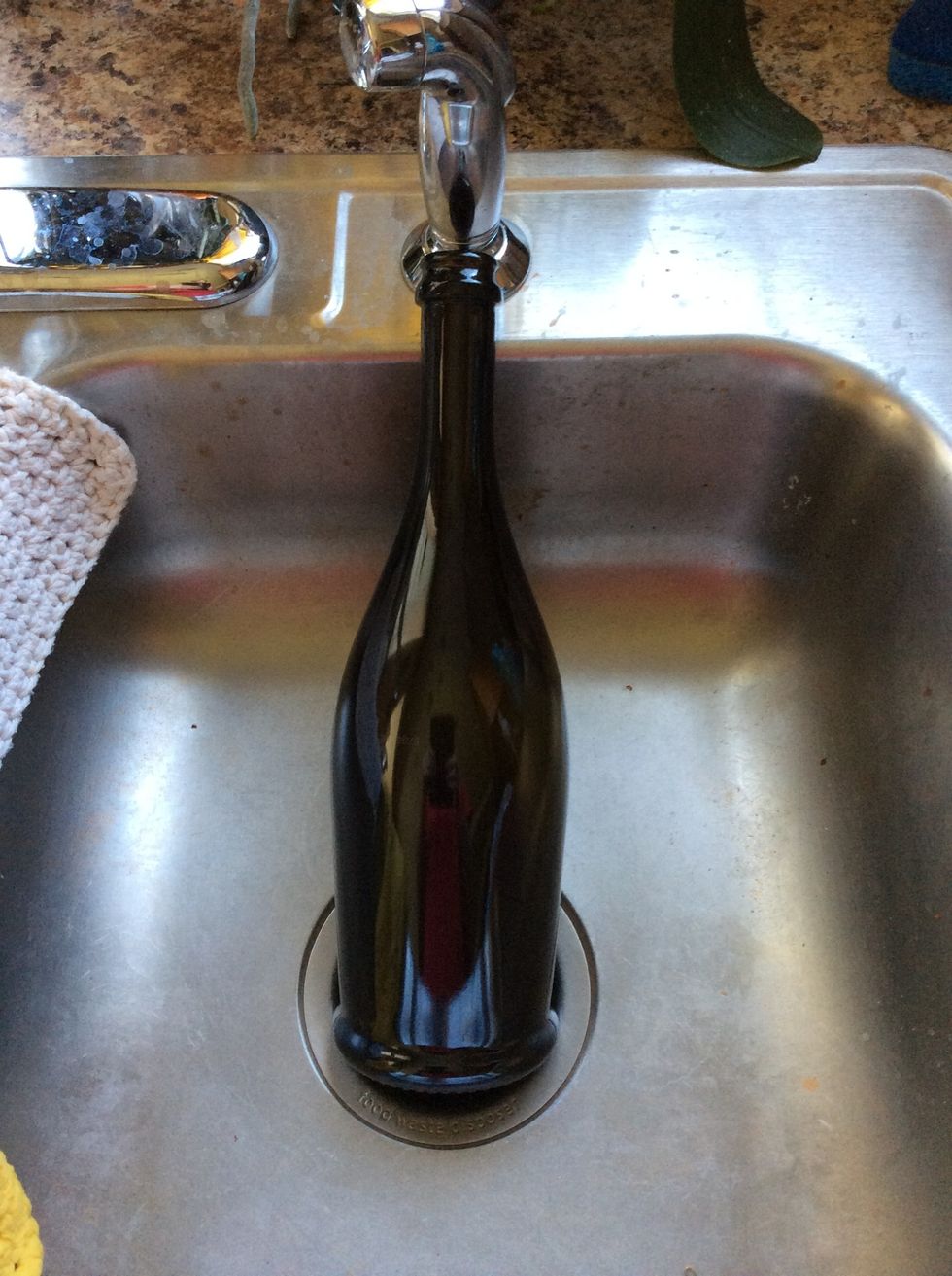 Remove label from wine bottle by soaking soapy water for a few hours. Remove what you can of the label and use a product like goo gone to remove any leftover adhesive