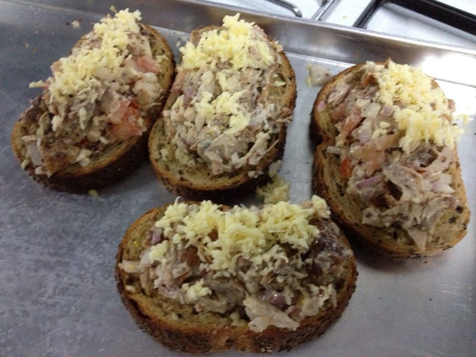 Remove lightly toasted garlic bread from oven and put chicken filling on the top as well as some cheese. Return to oven and toast till cheese melts and browning