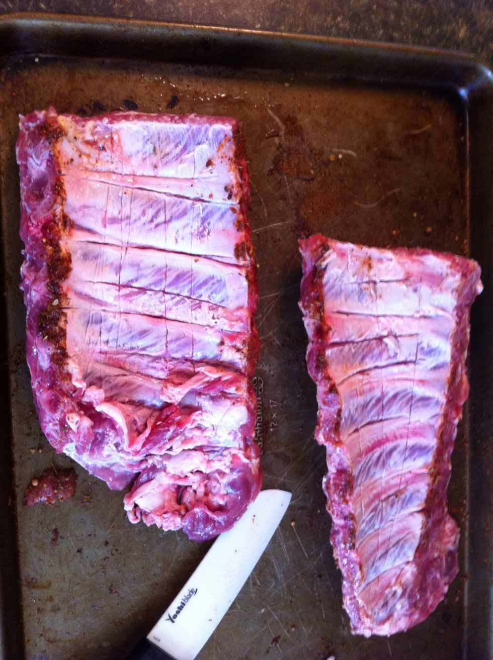 Remove membrane (thin white skin) from the back of the ribs. Place cut lines in between each rib as well.