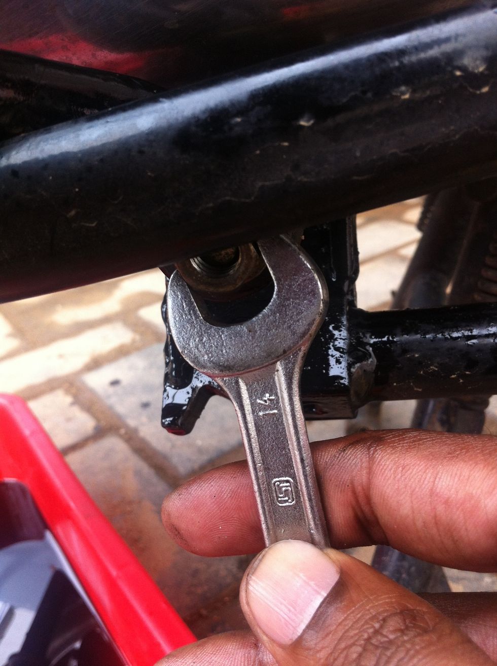 Remove or loosen the foot peg using a 14mm spanner