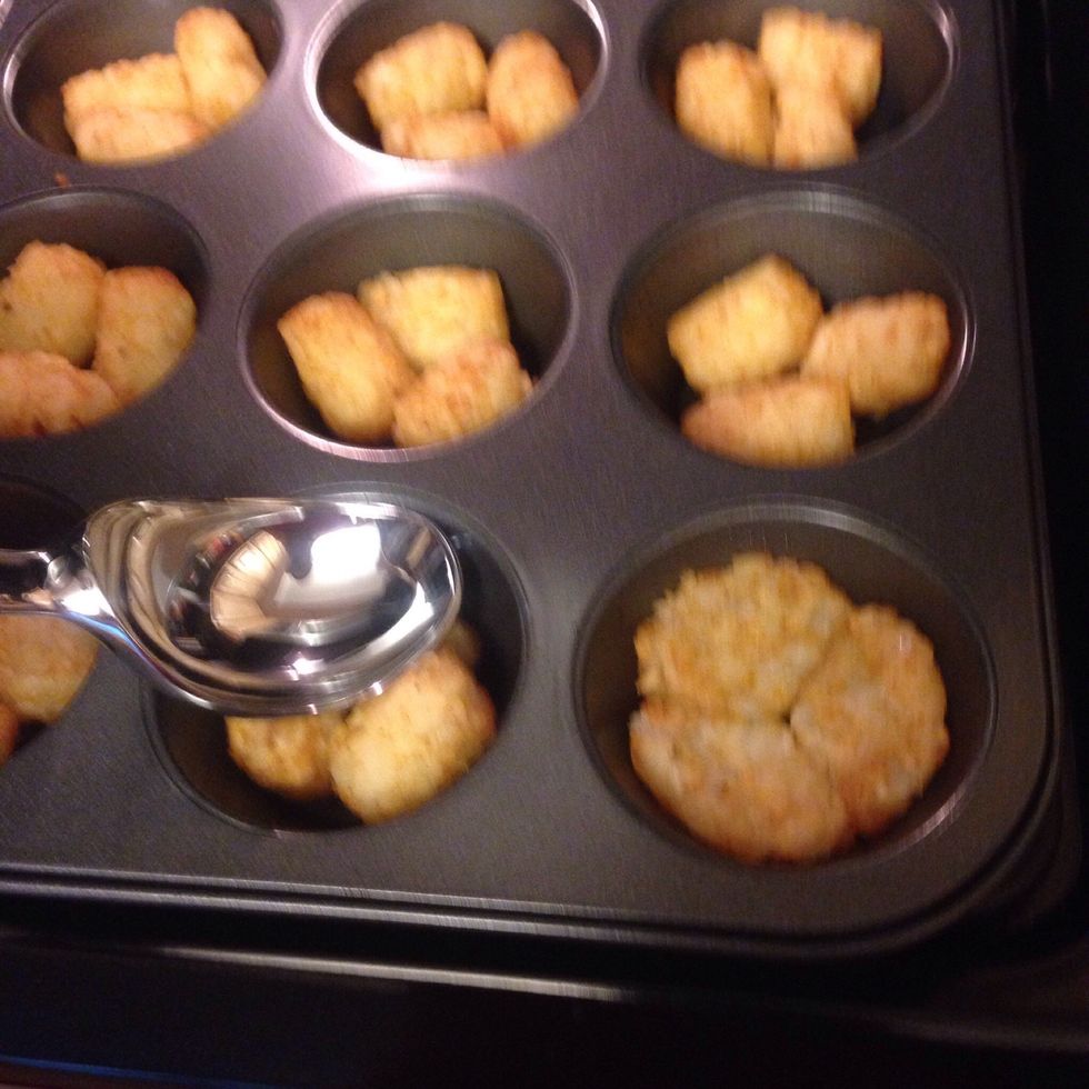 Remove pan from oven and press the tater tots down to form a base using the back of an ice cream scoop or a measuring cup.