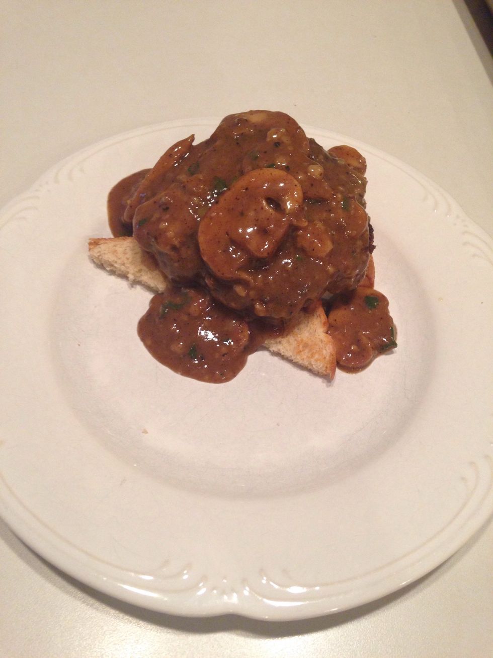 Remove patties from oven (if you haven't already taken them out) and put one patty on bread slices. Cover with mushroom gravy.