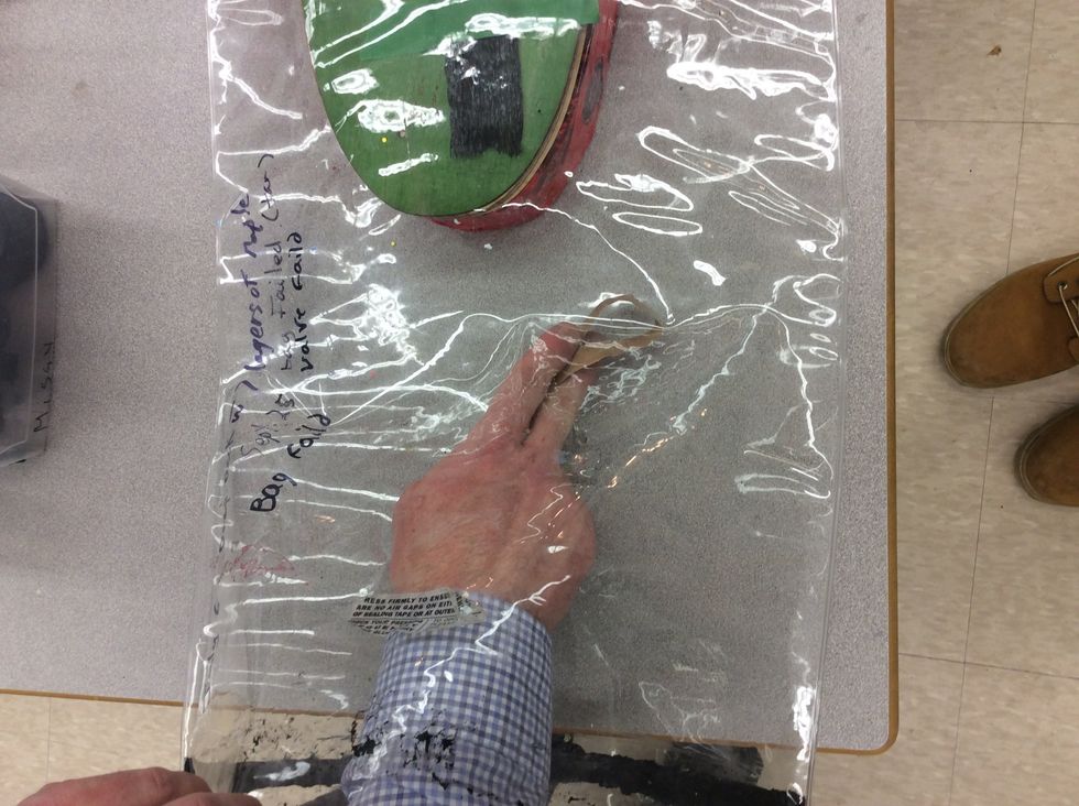 Remove protective paper from sealing tape and place in vacuum bag.