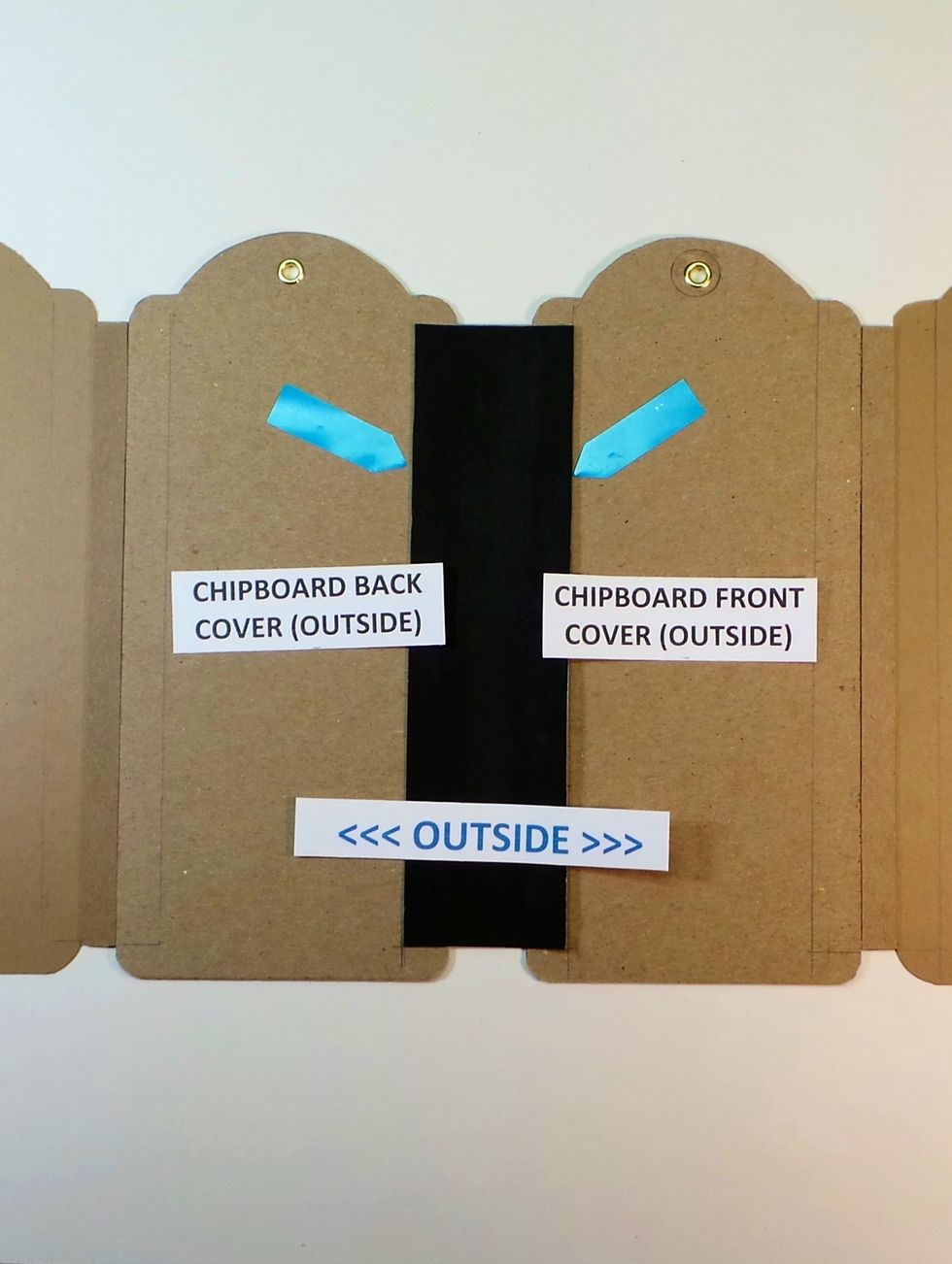 Remove Scor-Tape backing from CENTER ONLY of the other 1 7/8" Tyvek strip. Center on the outside Main Spine using the 1/2" guide lines (blue arrows). Burnish in center only.