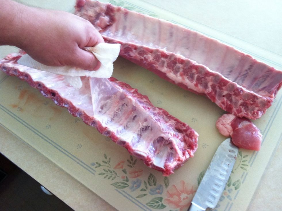 Remove silver skin.  Start from the narrow end of the rack and lift the corner of the silver skin with the tip of your knife.  Then, grab with a paper towel and pull back firmly to remove.
