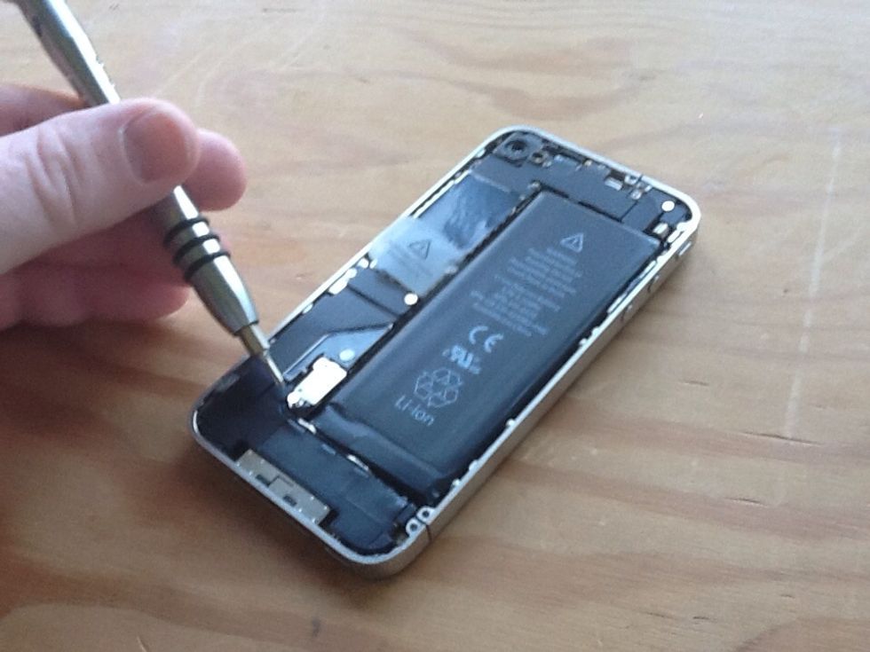 Remove small screw that is on the top of the battery connector and the antenna.