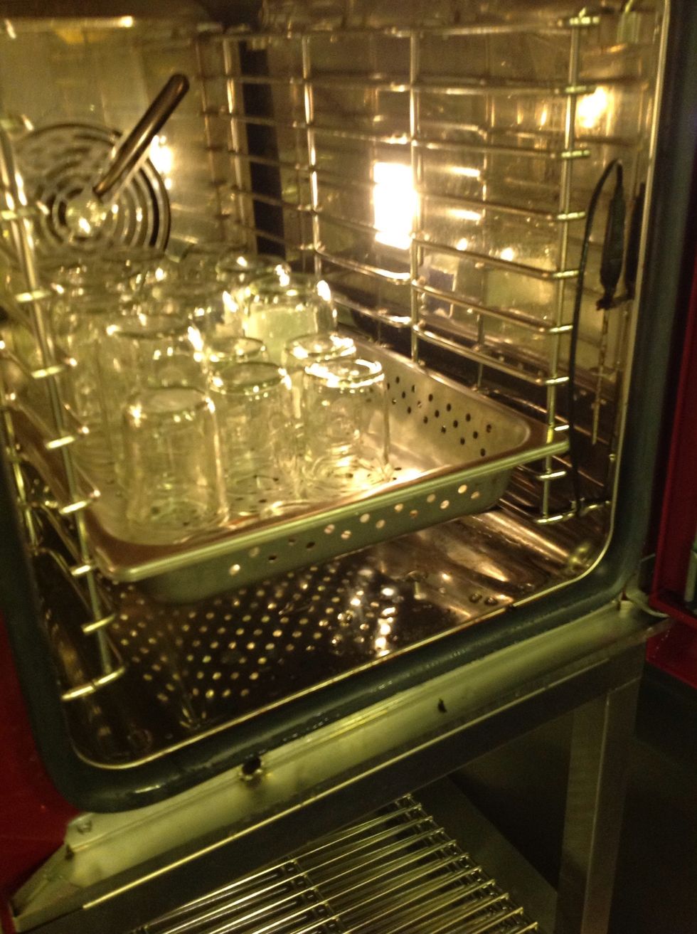 Remove sterilized mason jars from combi oven.