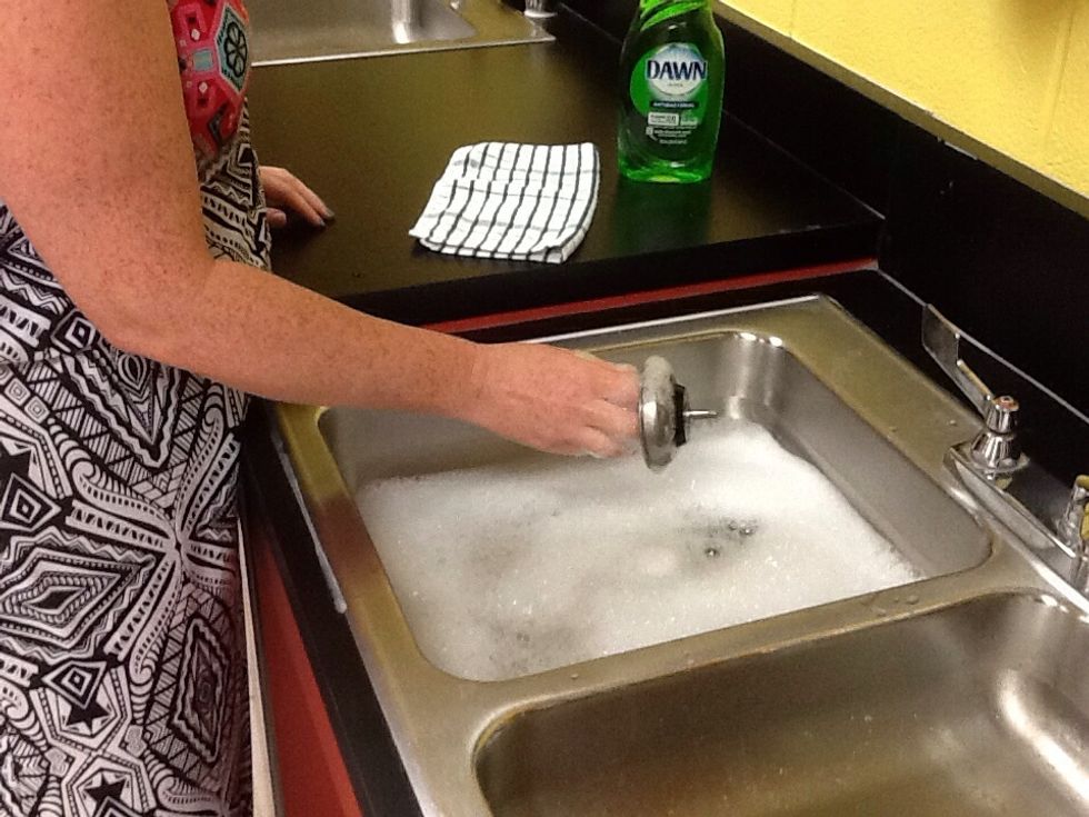 Remove stopper from sink to allow dirty water to drain.