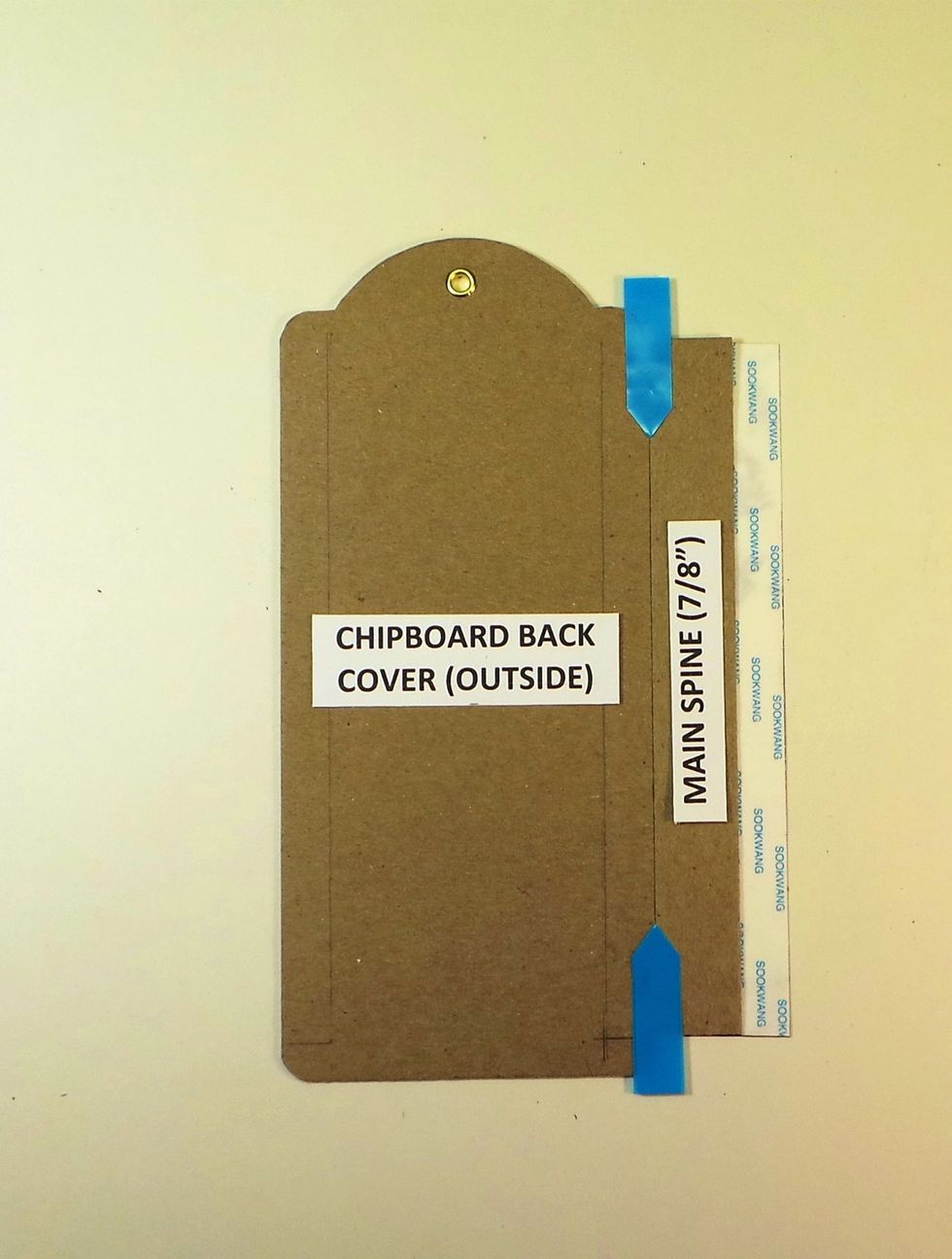 Remove tape backing from center of Tyvek strip and add main chipboard (7/8") spine, butting it against chipboard tag. Line up top and bottom edges of spine with Tyvek. Blue arrows = butt joint.