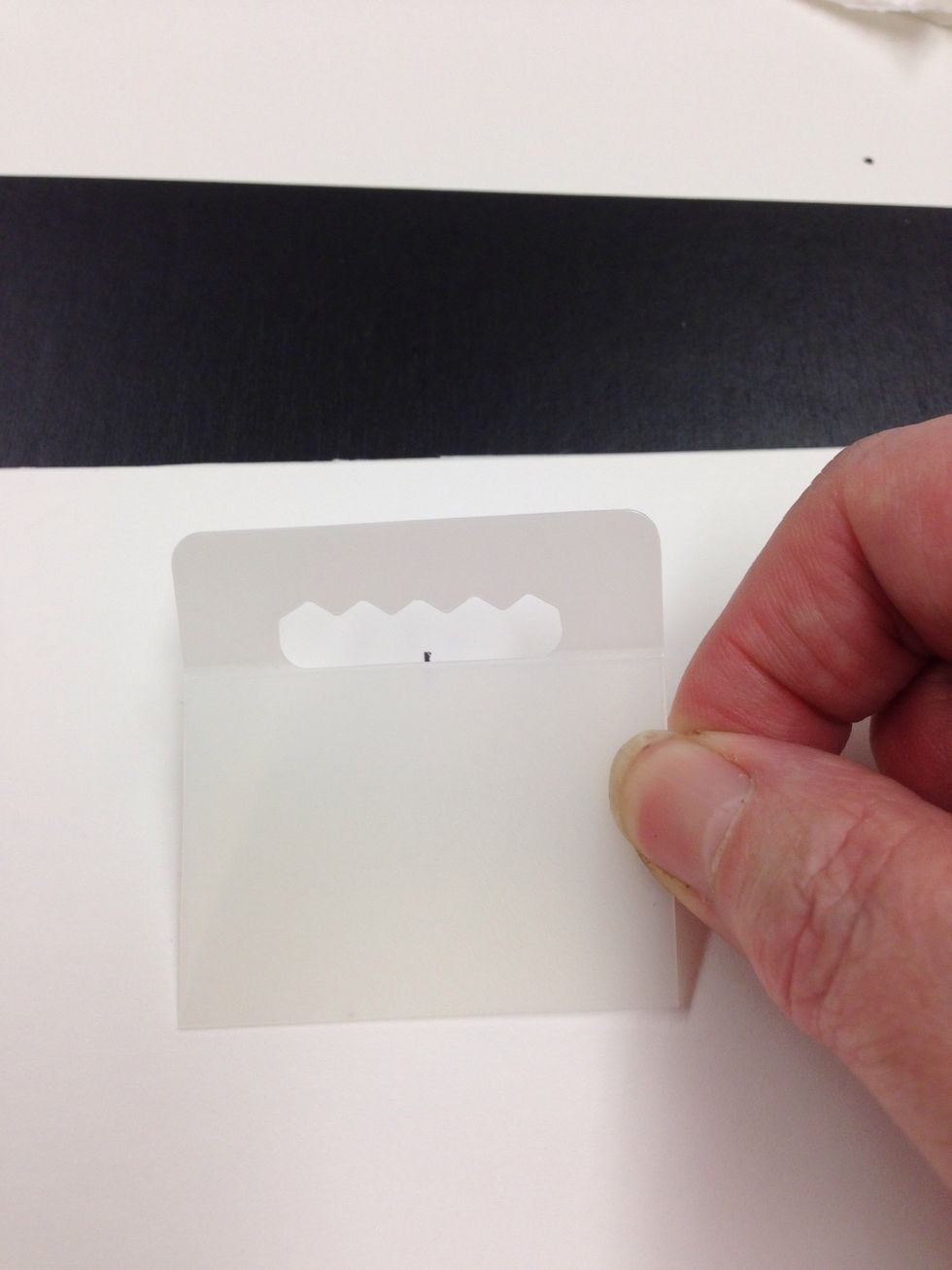 Remove the adhesive from the picture hanger and adhere it to your picture using the mark for centering.