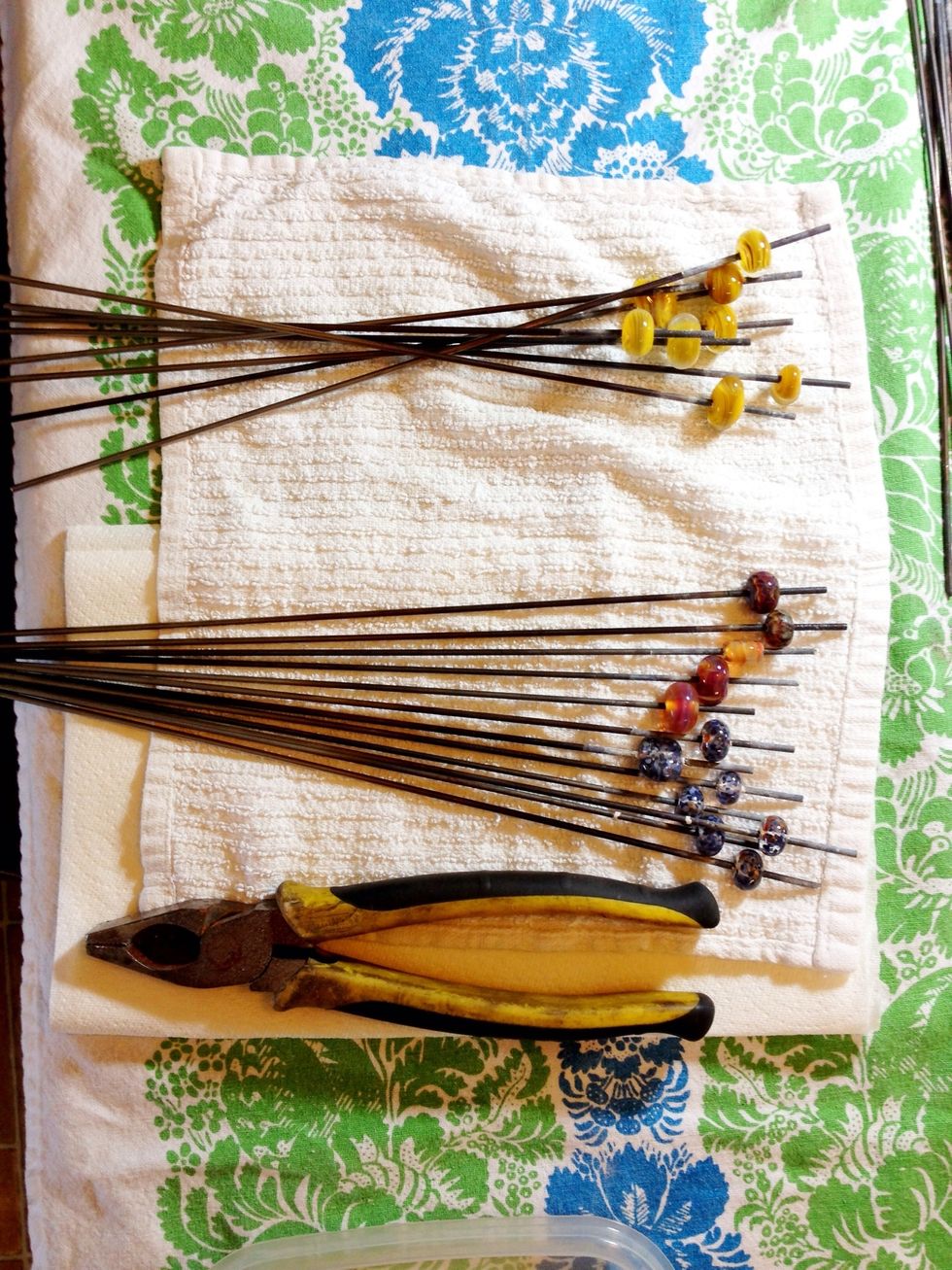 Remove the beads from the steel mandrels by using a pair of pliers to grip the mandrel and twisting the bead off the end of the mandrel. Don't expect this part to be very fun.