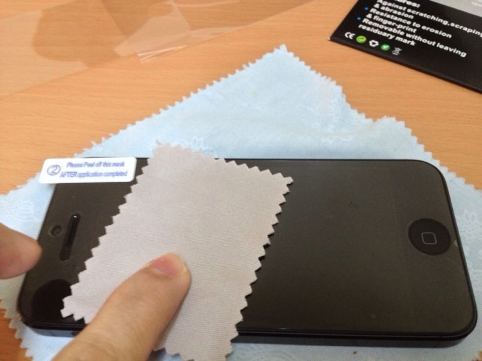 Remove the bubbles using the microfiber cloth. I don't recommend using a card because it causes scratches.