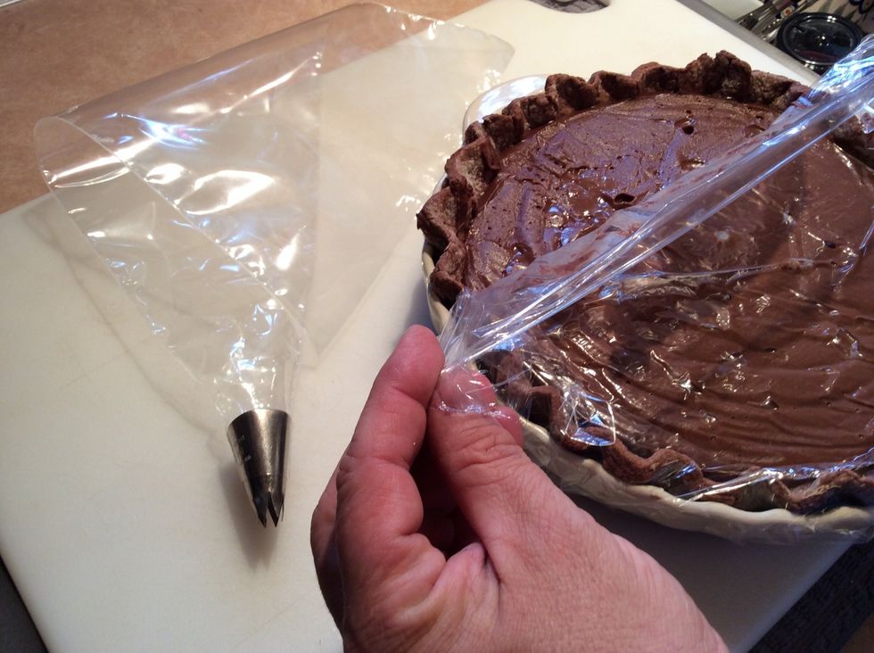 Remove the chilled pie from the refrigerator and peel back the plastic wrap to remove. I have a plastic pastry bag fitted with a large star tip to decorate the top of the pie.