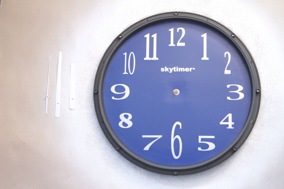 Remove the clock hands from the interior face of the clock. On most inexpensive clocks, you will pull up on the center pin, then lift off the clock hands.
